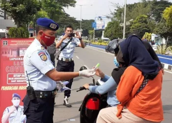 BAGIKAN MASKER DAN HAND SANITIZER: Budi Riswanto saat membagikan masker dan hand sanitizer kepada pengguna jalan, di depan Lapas Klas III Rangkasbitung, Kamis (23/4). (MULYANA/SATELIT NEWS)