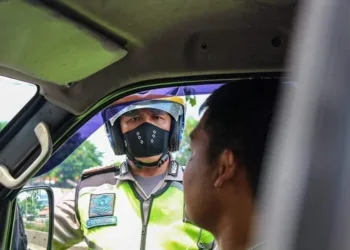 CHECK POINT: Seorang polisi melakukan pengawasan di check poin di wilayah Kota Tangerang beberapa waktu lalu. (DEDE KURNIAWAN/SATELIT NEWS)