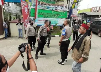 BERJAGA: Aparat kepolisian berjaga di lokasi bentrokan di kawasan Kecamatan Pinang, Kota Tangerang, Jumat (7/8). (IRFAN/SATELIT NEWS)