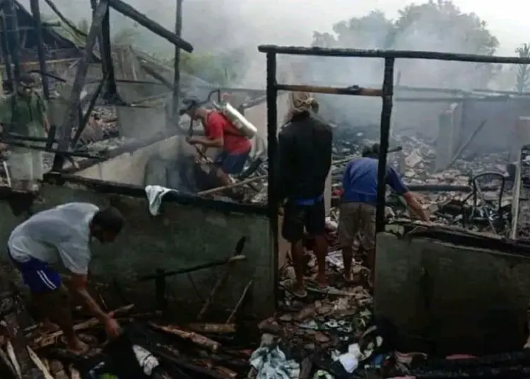 BERSIHKAN PUING: Warga Kampung Bubuay, Kecamatan Pangarangan saat membersihkan puing material rumah yang terbakar, Selasa (4/8). (MULYANA/SATELIT NEWS)