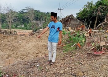 BELUM DIRELOKASI: Warga saat menunjukan salah satu makam di Desa Kaduagung Tengah, Kecamatan Cibadak yang belum bisa direlokasi lantaran belum adanya ahli waris, Selasa (18/8). (MULYANA/SATELIT NEWS)