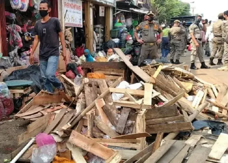 DITERTIBKAN: Petugas Satpol PP kota Tangsel menertibkan para pedagang yang berjualan di bahu jalan raya kawasan Pasar Serpong, Senin (3/8). (JARKASIH/SATELIT NEWS)