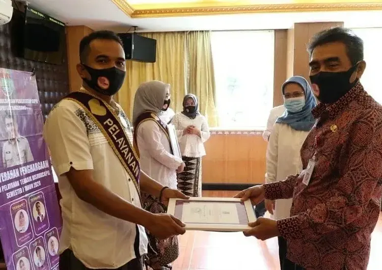 PIAGAM PENGHARGAAN: Kepala Disdukcapil Kabupaten Tangerang Syafrudin didampingi Sekdisdukcapil Yeni Suryani, menyerahkan piagam penghargaan dan uang kadedeuh kepada salah satu pegawai pelayanan Top 9 Non PNS terbaik, di sebuah rumah makan. (FAJAR ADITYA KUSUMA/SATELIT NEWS)