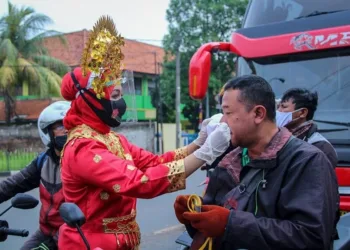 Pakai Baju Adat, Polisi Tangerang Bagikan Masker