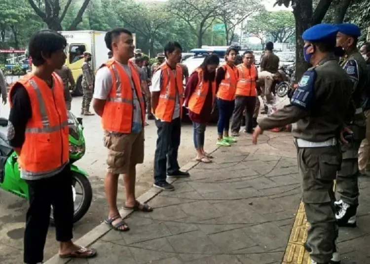 DIHUKUM: Aparat gabungan memberikan sanksi kepada para pelanggar, menghapal Pancasila dan menyanyikan lagu Indonesia Raya. (JARKASIH/SATELIT NEWS)