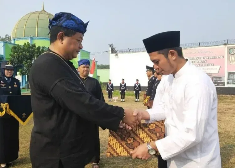 REMISI: Kepala Seksi Pelayanan Tahanan Rutan Kelas I Tangerang, David Sipahutar secara simbolis memberikan map remisi kepada salah satu Warga Binaan Rutan Kelas I Tangerang,  Kecamatan Jambe, beberapa waktu lalu. (DOK/SATELIT NEWS)