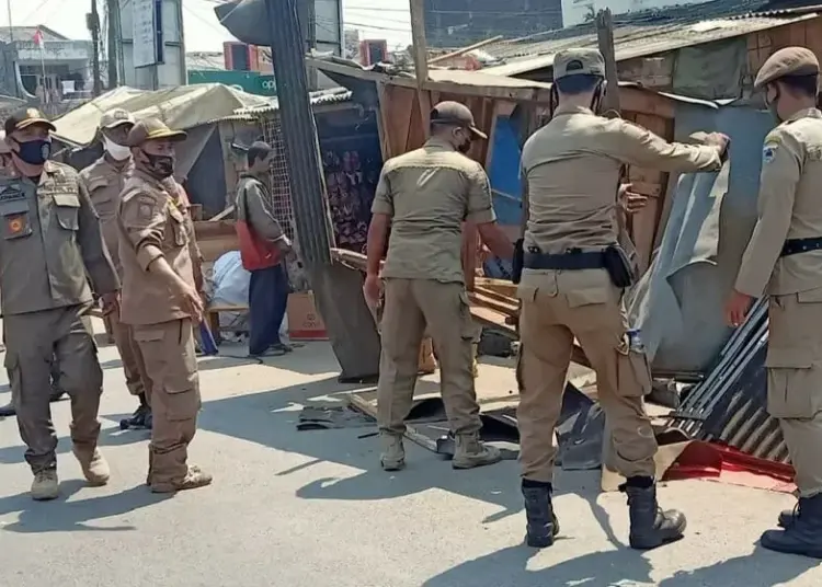 BONGKAR LAPAK: Satpol PP Kabupaten Pandeglang sedang membongkar lapak para PKL di Pasar Labuan, Senin (3/8). Para PKL itu telah direlokasi ke lantai dua Plaza Pasar Labuan. (NIPAL/SATELIT NEWS)