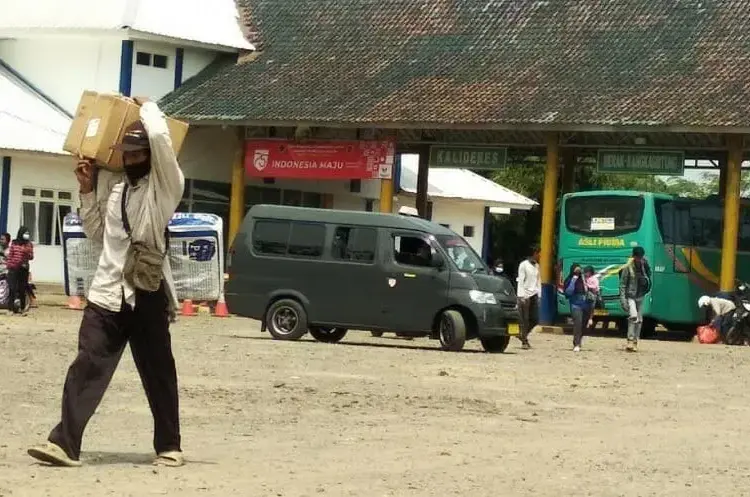 TERMINAL BUS: Penumpang yang turun dari bus di Terminal Labuan, sedang berjalan kaki sambi membawa barang bawaannya untuk kembali bergegas ke kediamannya, Senin (3/8). (NIPAL/SATELIT NEWS)