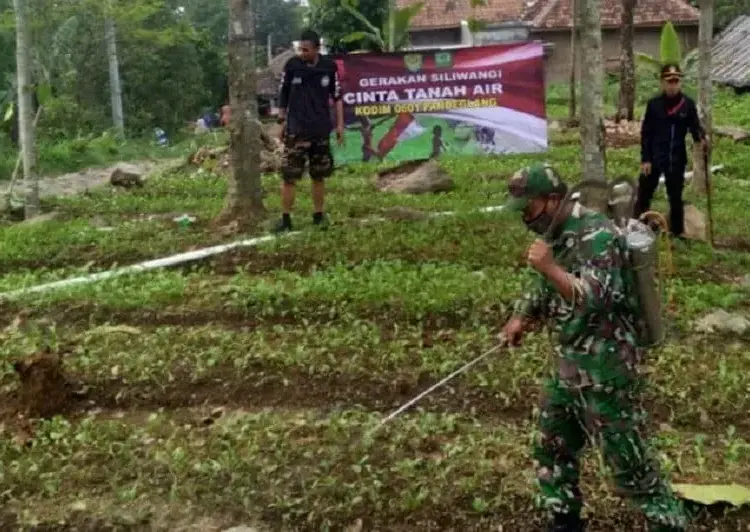 PENYEMPROTAN: Jajaran Kodim 0601 Pandeglang sedang melakukan penyemprotan tanaman menggunakan pupuk bios 44 di salah satu lahan milik warga Pandeglang. (NIPAL/SATELIT NEWS)