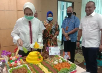 POTONG TUMPENG: Walikota Tangsel Airin Rachmi Diany memotong tumpeng perayaan ulang tahunnya yang ke-44 di ruang kerjanya, Puspemkot Tangsel, Ciputat, Jumat (28/8). Tampak sejumlah pejabat dan staf Pemkot Tangsel hadir di perayaan yang digelar sederhana tersebut. (IRMA/BNN)