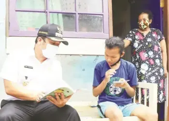 LIHAT BUKU: Walikota Tangerang Arief Wismansyah tampak melihat buku pelajaran dan berbincang dengan salah seorang siswa saat meninjau progres pemasangan fasilitas internet gratis untuk sarana Pembelajaran Jarak Jauh (PJJ) di Kantor Kelurahan Parung Jaya, Kecamatan Karang Tengah, Rabu (12/8). (ISTIMEWA)