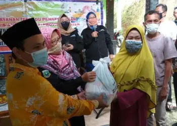 SIMBOLIS: Wakil Ketua P2TP2A Provinsi Banten, Yayah Ruhiyah didampingi Ketua RW secara simbolis memberikan bantuan sembako kepada warga Kampung Canggoang, Kelurahan Juhut, Kecamatan Karangtanjung, Kamis (10/9). (NIPAL/SATELIT NEWS)