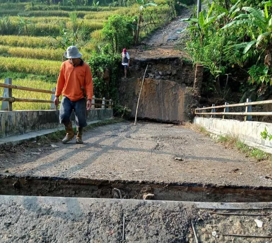 MELINTASI JEMBATAN PUTUS: Seorang warga saat melintasi jembatan putus akibat di terjang banjir di Desa Hariang, Kecamatan So bang. Putusnya jembatan tersebut akibat meluapnya sungai Cimodene Girang, pasca diguyur hujan deras. (DOK BPBD LEBAK)