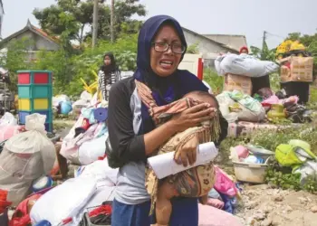 MENANGIS : Seorang ibu menangis sembari menggendong anaknya ketika rumahnya dirobohkan di Kampung Baru Kelurahan Jurumudi Kecamatan Benda Kota Tangerang, Selasa (1/9). (DEDE KURNIAWN/ SATELIT NEWS)