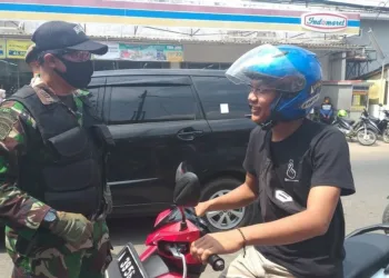 BERI PEMAHAMAN: Komandan Koramil 0101 Pandeglang, Kapten Inf Supandi, sedang memberikan pemahaman dan memberikan sanksi menyanyikan lagu kebangsaan kepada pengendara yang tak menggunakan masker di Jalan Raya Pandeglang-Labuan, Selasa (8/9). (NIPAL/SATELIT NEWS)