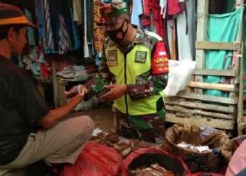 INGATKAN PEDAGANG: Anggota Koramil 0107 Saketi sedang meningatkan para pedagang di Pasar Saketi, agar menerapkan protokol kesehatan. Salah satunya wajib mengenakan masker, Rabu (2/9). (NIPAL/SATELIT NEWS)