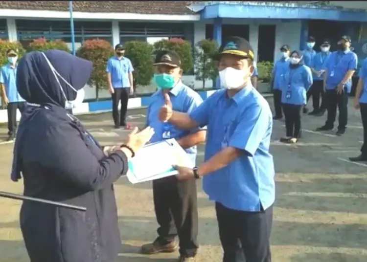 BERI PENGHARGAAN–Kabag Keuangan PDAM Tirta Berkah Pandeglang, Euis Yuningsih, secara simbolis memberikan penghargaan kepada perwakilan karyawan, di halaman PDAM Tirta Berkah Pandeglang, Senin (5/7). (ISTIMEWA)