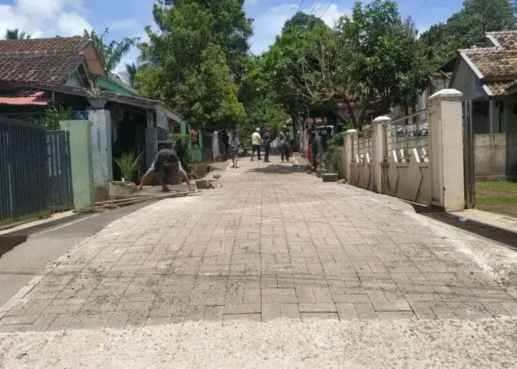 JALAN POROS DESA–Petugas DPKPP Pandeglang, sedang memeriksa hasil pembangunan jalan poros desa menggunakan paving block, di Kampung Parigi, Desa Parigi, Kecamatan Saketi, Kabupaten Pandeglang, beberapa waktu lalu. (ISTIMEWA)