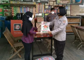 PENYALURAN BANTUAN SEMBAKO–Kabag Logistik Polres Pandeglang, AKP Reni Widowati, memberikan bantuan kepada seorang pedangang Wisata Kuliner Pandeglang Gedung Juang 45 Kabupaten Pandeglang, Senin (2/8/2021). (NIPAL SUTIANA/SATELITNEWS.ID)