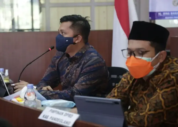 Wabup Pandeglang, Tanto Warsono Arban didampingi Wakil Ketua DPRD Pandeglang, Tubagus Asep Rafiudin Arief, mengenakan peci hitam dan berkacamata, sedang memberikan arahan secara virtual di ruang Pintar Setda Pandeglang, Kamis (12/8/2021). (NIPAL SUTIANA/SATELITNEWS.ID)