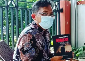 SUTOTO–Sekretaris Dindikbud Pandeglang, Sutoto, sedang menunjukan buku yang kerap dibacanya diwaktu segang. (DOKUMEN PRIBADI)