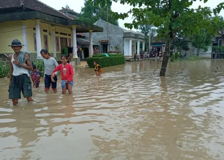 BANJIR - Sejumlah warga di Kecamatan Tunjungteja, Kabupaten Serang, melintasi banjir yang melanda wilayahnya, Selasa (9/8). (sidik/mardiana)