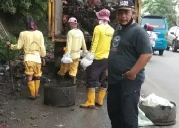 Petugas kebersihan mengangkut sampah di Jalan Raya Serang - Cilegon, tepatnya di Kecamatan Kramatwatu, belum lama ini. (ISTIMEWA)