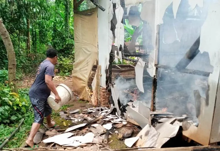 PEMADAMAN–Seorang warga berusaha memadamkan api, yang membakar rumah Anis Sutiani (32), warga Kampung Bangbayang, RT 10 RW 02, Desa Waringin, Kecamatan Mancak, Kabupaten Serang, Minggu (12/9/2021). (SIDIK/SATELITNEWS.ID)