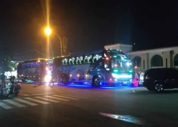 BERANGKAT–Dua unit bus di depan Masjid Agung Ar-Rahman, Rabu (27/10/2021) malam, yang digunakan pegawai Disdukcapil Pandeglang untuk Family Gathering ke Yogyakarta. (NIPAL SUTIANA/SATELITNEWS.ID)