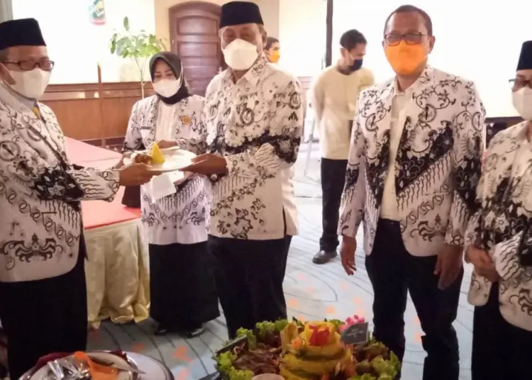 Wakil Bupati Serang Pandji Tirtayasa (kanan), memberikan potongan tumpeng kepada Ketua PGRI Kabupaten Serang (kiri), saat memperingati HUT PGRI di salah satu hotel di Anyer, Kamis (25/11/2021). (ISTIMEWA)