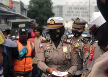 Kepala Satuan (Kasat) Lantas Polres Pandeglang, AKP Jeany Viadiniati, sedang membagikan masker kepada masyarakat di Pasar Pandeglang, beberapa waktu lalu. (ISTIMEWA)