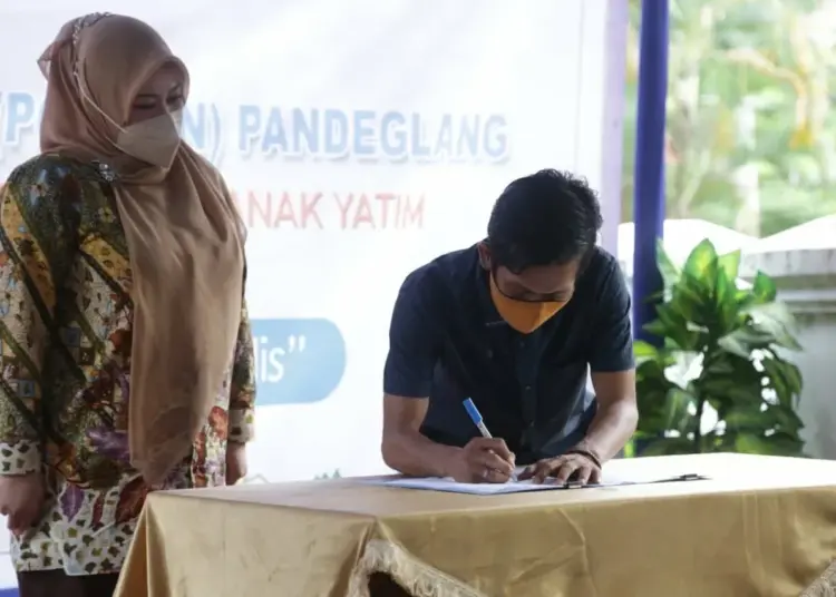 Ketua Porwan Pandeglang, Nipal Sutiana, menandatangani surat tanda terima guna pakai gedung Porwan, disaksikan Bupati Pandeglang Irna Narulita, Kamis (4/11/2021). (MARDIANA/SATELITNEWS.ID)