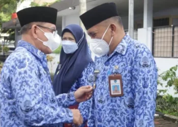 Pj Sekda Pandeglang, Taufik Hidayat, secara simbolis memasangkan lencana kepada pejabat yang berhak, di halaman Setda Pandeglang, Senin (29/11/2021). (ISTIMEWA)