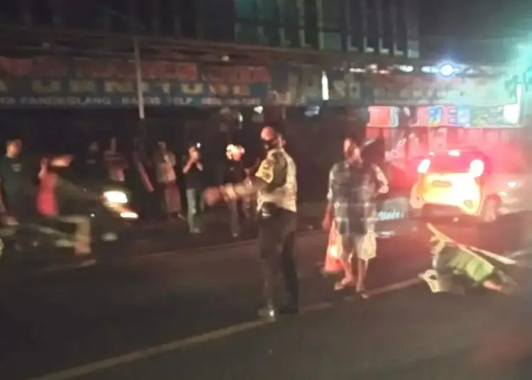 Seorang pengendara yang tewas usai kecelakaan, tergeletak di tengah jalan. Petugas kepolisian dari Polres Serang Kota, langsung turun tangan mengevakuasi korban, Rabu (24/11/2021) malam. (ISTIMEWA)