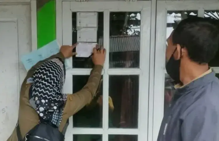 Petugas sedang memasang stiker di jendela rumah warga, di Kelurahan Pandeglang, yang sudah disutik vaksin Covid-19, Jumat (3/12/2021). (ISTIMEWA)