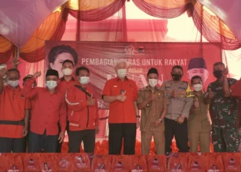 Anggota Komisi III DPR RI Fraksi PDI Perjuangan, Ichsan Soelistio, berfoto bersama saat pembagian beras, di Kecamatan Baros, Kabupaten Serang, Selasa (28/12/2021). (ISTIMEWA)