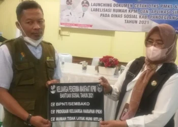 LABELISASI RUMAH KPM BANSOS–Kepala Dinsos Pandeglang, Nuriah, bersama Ketua Boedak Saung Kabupaten Pandeglang, Entus Hunaeni, menunjukkan cetakan untuk labelisasi rumah KPM Bansos di Kabupaten Pandeglang, Selasa (21/12/2021). (NIPAL SUTIANA/SATELITNEWS.ID)