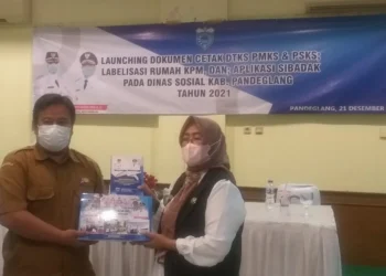 SERAHKAN BUKU–Kepala Dinsos Pandeglang, Nuriah, secara simbolis menyerahkan buku berbasis data kepada pihak Kecamatan, di salah satu rumah makan di Pandeglang. (ISTIMEWA)