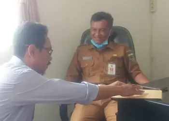 Direktur ALIPP, Uday Suhada sedang menyerahkan uang koin kepada Kadispora Pandeglang, Dadan Saladin, di ruang kerjanya, Senin (20/12/2021). (NIPAL SUTIANA/SATELITNEWS.ID)