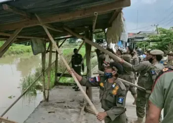 BONGKAR PAKSA–Anggota Dinas Satpol PP Kabupaten Serang, membongkar paksa bangunan liar di sepadan saluran irigasi Pamarayan, di Kecamatan Kibin, Kabupaten Serang, Selasa (25/1/2022). (SIDIK/SATELITNEWS.ID)