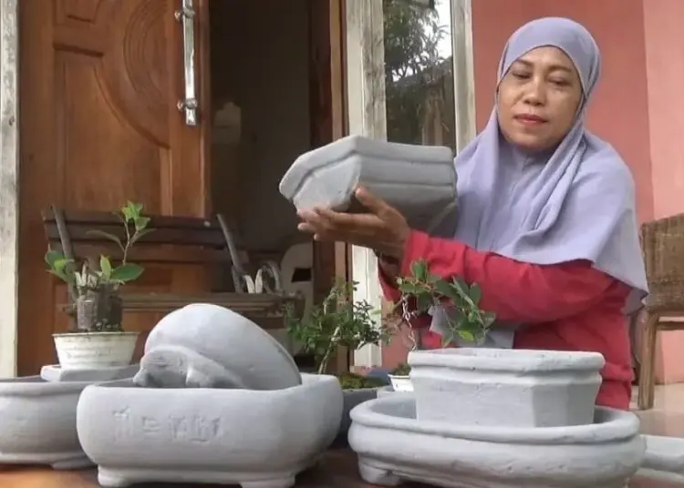 Tuti Ratulanes (50), sedang menunjukan hasil karyanya dari bahan limbah bata hebel. (ISTIMEWA)