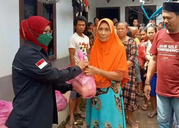 PENYALURAN BANTUAN–Kepala Desa (Kades) Idaman, Ilman, mendampingi dan menyaksikan penyaluran bantuan kepada para korban banjir di Desa Idaman, Kecamatan Patia, Kabupaten Pandeglang, Minggu (13/3/2022). (ISTIMEWA)