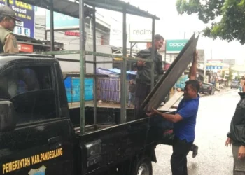 Sejumlah petugas Pol PP dan Muspika Labuan, sedang menertibkan PKL yang berjualan disekitar eks Puskesmas Labuan, Senin (7/3/2022). (ISTIMEWA)