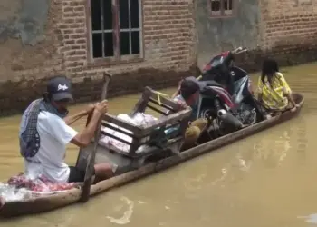 Warga Desa Rancasanggal, Kecamatan Cinangka, Kabupaten Serang, beraktivitas menggunakan perahu jukung (perahu kecil). Karena, genangan air masih merendam rumah dan kawasannya, Kamis (3/3/2022). (ISTIMEWA)