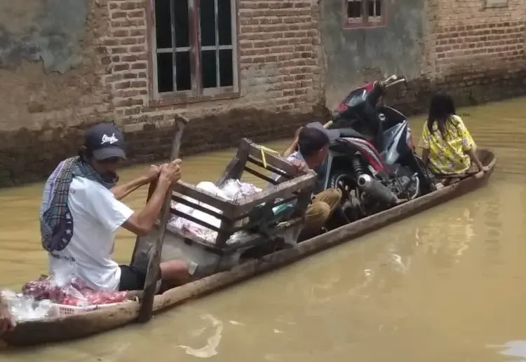 Warga Desa Rancasanggal, Kecamatan Cinangka, Kabupaten Serang, beraktivitas menggunakan perahu jukung (perahu kecil). Karena, genangan air masih merendam rumah dan kawasannya, Kamis (3/3/2022). (ISTIMEWA)