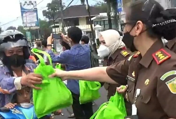 BERBAGI TAKJIL–Jaksa di Kejari Pandeglang bersama wartawan, berbagi takjil kepada para pengendara yang melintas di Jalan Raya Pandeglang-Serang, Rabu (13/4/2022). (NIPAL SUTIANA/SATELITNEWS.ID)