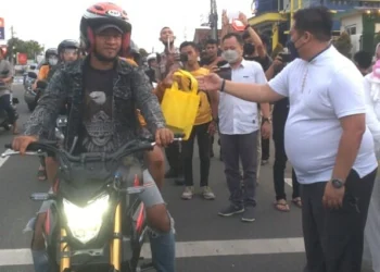 BERBAGI TAKJIL–Ketua PN Pandeglang, Titis Wulandari, didampingi jajarannya memberikan takjil ke pengendara yang melintas di jalan Raya Pandeglang – Serang, Rabu (20/4/2022). (NIPAL SUTIANA/SATELITNEWS.ID)