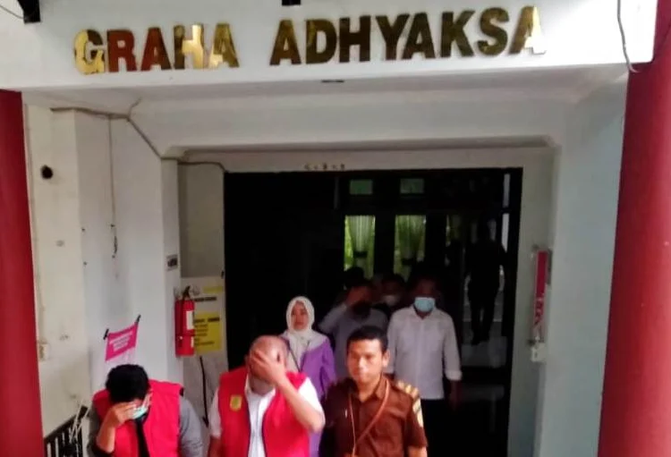 TERSANGKA KORUPSI–Mantan Kepala Dinas LH Kabupaten Serang, Sri Budi Prihasto, bersama tiga tersangka lainnya, dikawal petugas dari Kejari Serang dan Mapolda Banten, untuk dititipkan ke Rutan Serang, Senin (30/5/2022) sore. (Herman Saputra/Satelitnews.id)