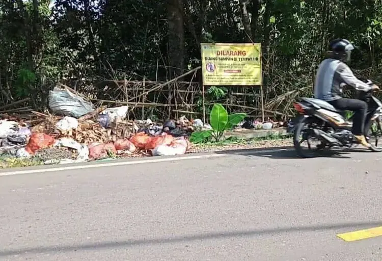 Sampah terlihat menumpuk dan berserakan di pinggir Jalan Raya AMD Lintas Timur Pandeglang, padahal terpangpang papan larangan buang sampah, Senin (16/5/2022). (ISTIMEWA)