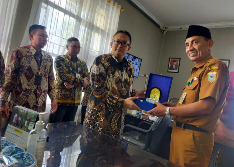 Kepala Bapenda Pandeglang, Tatang Muhtasar sedang menerima cendermata dari pihak Bank Banten, di kantor Bapenda setempat, Selasa (7/6/2022). (ISTIMEWA)